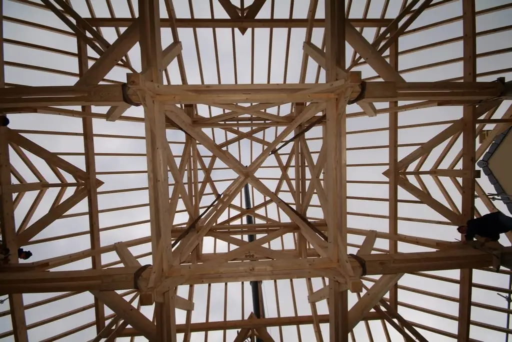 Charpente traditionnelle en bois vue de l’intérieur, entraits et arêtiers apparents.