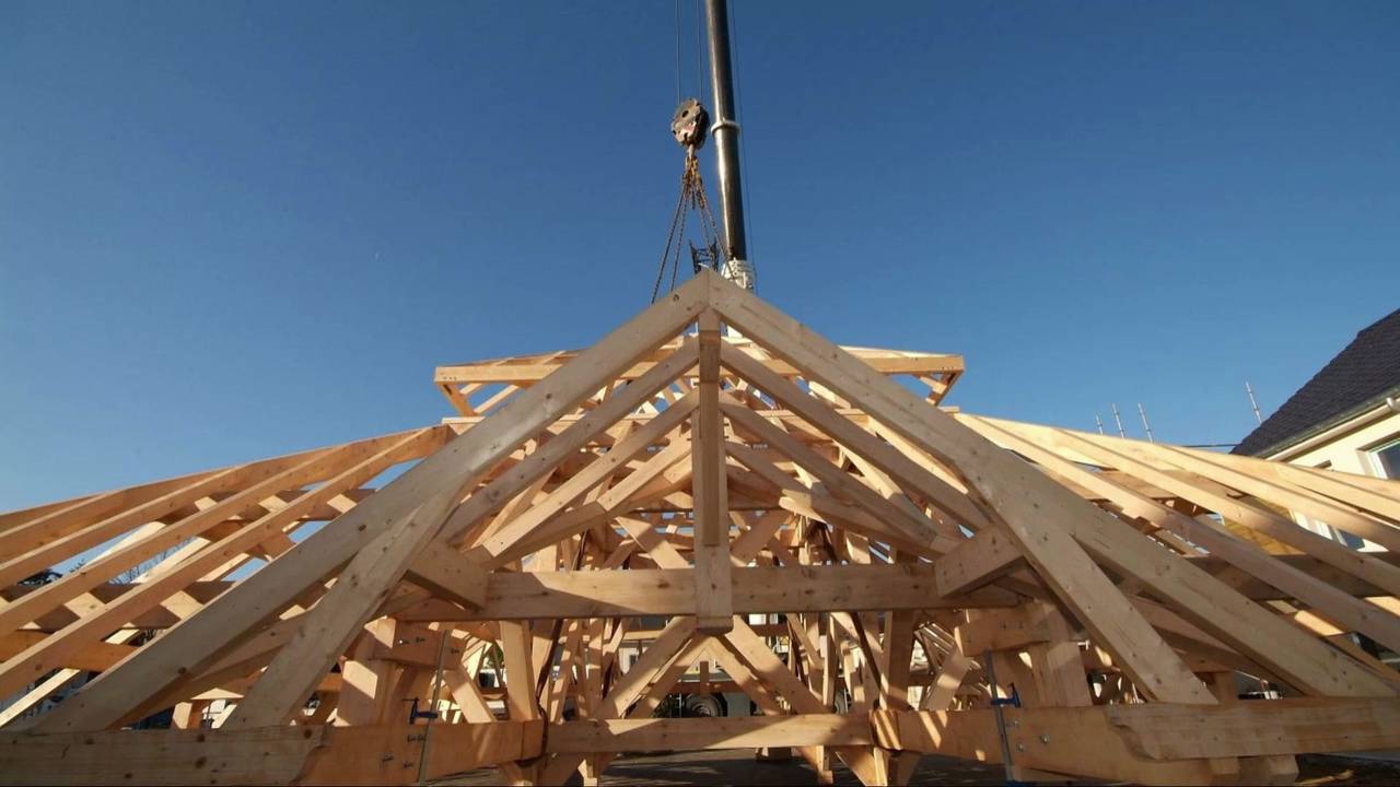 Levage à la grue d’une charpente pyramidale en bois taillée par BATI-CHARPENTE.